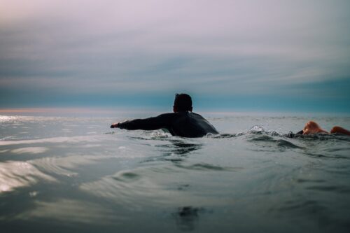 Golfsurfen met wetsuit aan met koude watertemperatuur